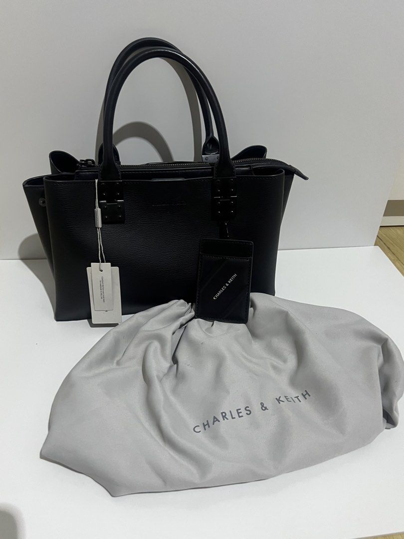 Charles & Keith Black Tote Bag with Cardholder (Category: Tote Bags) located in Manila. Submitted by avelineco (Listing ID 1464730084, Image 2). Description: - Brand: Charles & Keith - Color: Classic Black - Material: Textured faux leather - Closure: Secure top zipper - Carry options: Dual top handles and detachable shoulder strap with chic chain accent - Inclusions: Matching cardholder and original dust bag - Condition: Brand new with retail tag