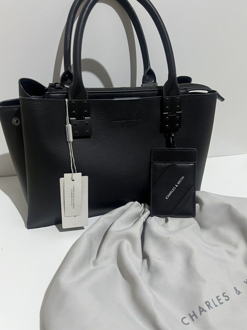 Charles & Keith Black Tote Bag with Cardholder (Category: Tote Bags) located in Manila. Submitted by avelineco (Listing ID 1464730084, Image 3). Description: - Brand: Charles & Keith - Color: Classic Black - Material: Textured faux leather - Closure: Secure top zipper - Carry options: Dual top handles and detachable shoulder strap with chic chain accent - Inclusions: Matching cardholder and original dust bag - Condition: Brand new with retail tag