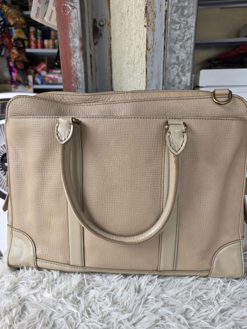 Rare Coach beige leather structured handbag tote bag (Category: Luxury Bags & Wallets) located in Lemery. Submitted by venus23 (Listing ID 1464700814, Image 2). Description: - Brand: Coach - Color: Beige textured leather with smooth cream trim - Style: Structured handbag / tote - Dimensions: Approximately 14 inches wide - Handles: Dual top grab handles with metallic hardware - Interior: Striped fabric lining with a zipped pocket and Coach creed p
