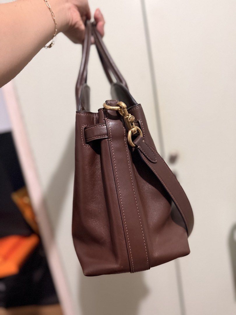 Coach Brown Leather Tote Handbag (Category: Luxury Bags & Wallets) located in San Juan City. Submitted by zenrabbit.6105c7 (Listing ID 1464691425, Image 3). Description: - Brand: Coach - Material: Genuine full-grain brown leather - Hardware: Gold-tone with protective metal feet - Straps: Dual top handles and adjustable shoulder strap - Features: Spacious interior, secure zip closure, and two colorful front hangtags - Condition: Clean structure wi