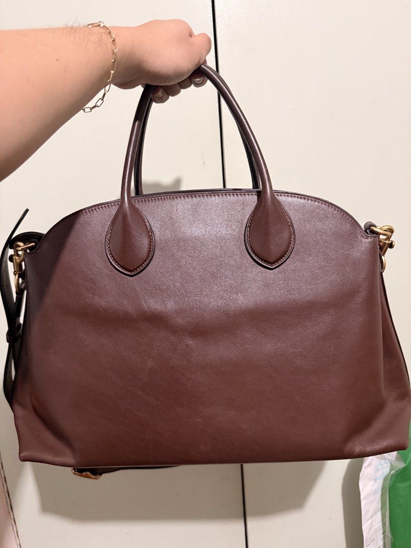 Coach Brown Leather Tote Handbag (Category: Luxury Bags & Wallets) located in San Juan City. Submitted by zenrabbit.6105c7 (Listing ID 1464691425, Image 2). Description: - Brand: Coach - Material: Genuine full-grain brown leather - Hardware: Gold-tone with protective metal feet - Straps: Dual top handles and adjustable shoulder strap - Features: Spacious interior, secure zip closure, and two colorful front hangtags - Condition: Clean structure wi