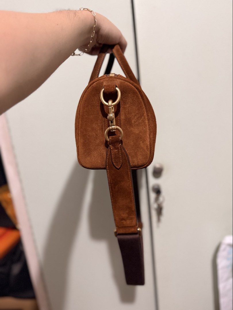 Coach Brown Suede Compass Bag with Strap (Category: Luxury Bags & Wallets) located in San Juan City. Submitted by zenrabbit.6105c7 (Listing ID 1464691271, Image 2). Description: - Authentic Coach suede compass bag in a rich brown shade - Elegant gold hardware details and classic Coach New York front logo - Includes matching top handles and a thick, adjustable dark brown crossbody strap - Secure top zipper closure - Complete with the signature lea
