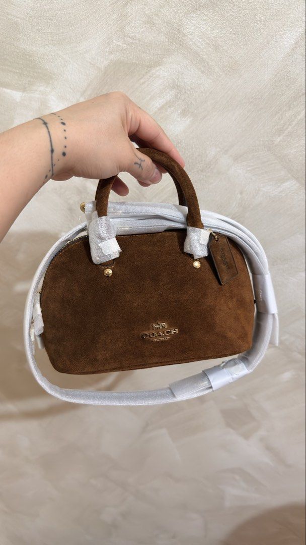 Coach Mini Lara (Category: Cross-body Bags) located in Las Pinas. Submitted by mharjrahm (Listing ID 1464732856, Image 1). Description: - Brand: Coach - Style: Brown suede mini satchel - Condition: brandnew with original packing materials still attached - Hardware: Gold-tone with front signature logo lettering - Handles: Top grab handles and a long shoulder strap (still wrapped in protective paper) - Inclusion: Original leather hangtag laspiñas l