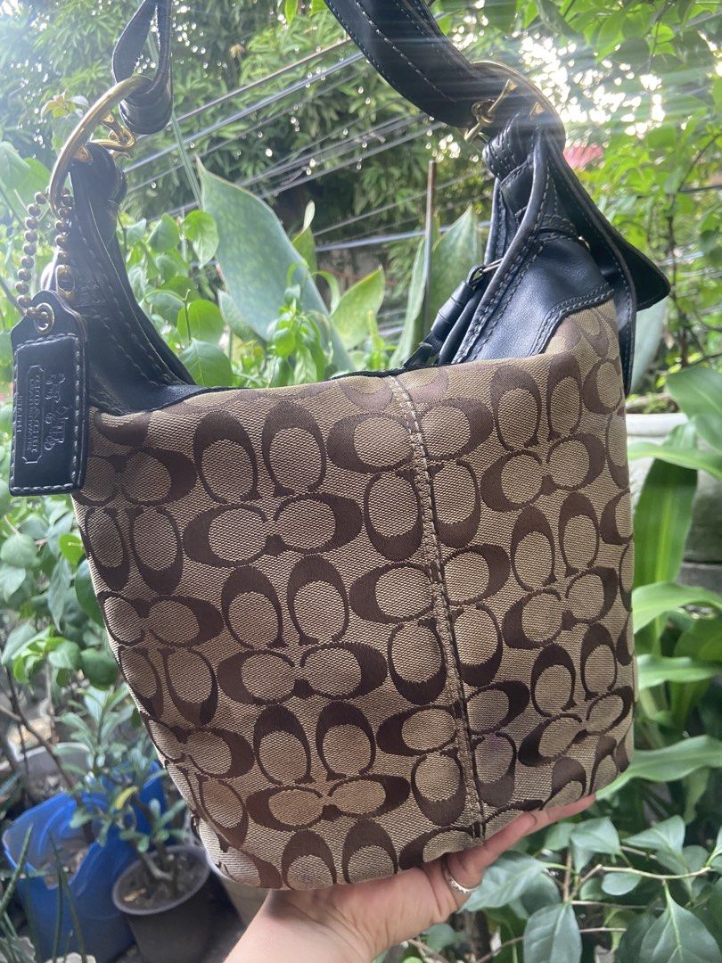 Coach Monogram Canvas Leather Hobo Shoulder Bag (Category: Luxury Bags & Wallets) located in Rizal. Submitted by rosemarievillaluna176 (Listing ID 1464647130, Image 2). Description: - Classic Coach hobo bag - Signature monogram canvas with black leather trim - Gold hardware details - Adjustable shoulder strap with buckle - Spacious interior for essentials - Timeless piece for everyday use With pen stain s pocket.