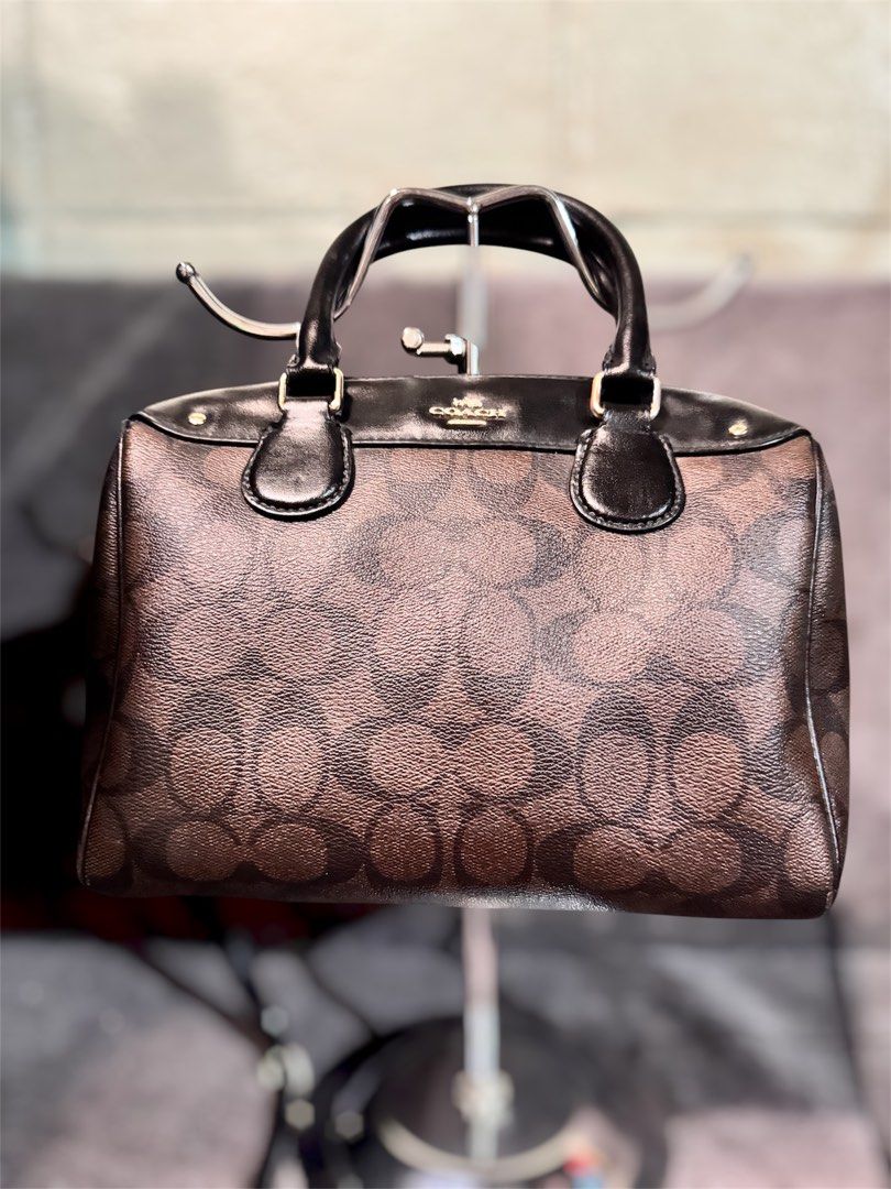 Coach Signature Monogram Brown Leather Handbag (Category: Luxury Bags & Wallets) located in Manila. Submitted by dearpinkcollections (Listing ID 1464682247, Image 1). Description: - Classic Coach monogram print handbag - Brown and black colorway - Genuine leather trim and handles - Secure zipper closure/ puller issue /slightly tarnish side sling - Detachable shoulder strap included - Elegant gold hardware details - Ideal for everyday use - Small 