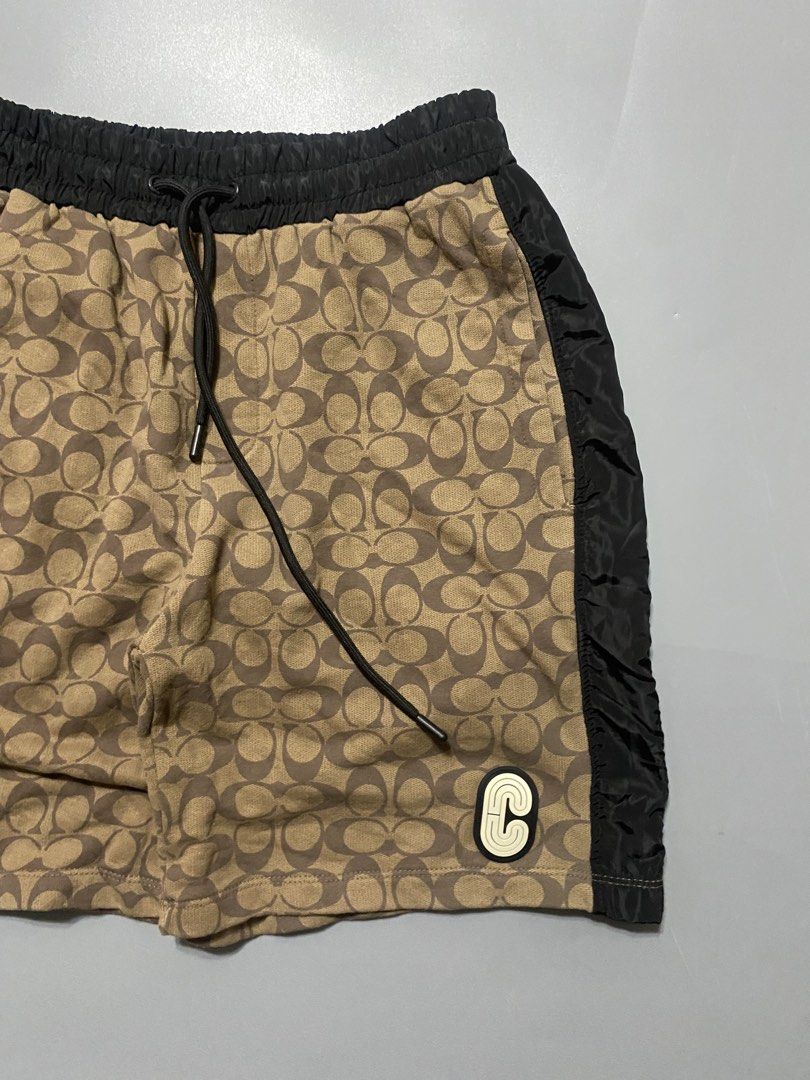 Coach Signature Pattern Track Shorts Medium (Category: Shorts) located in Silang. Submitted by kenneth_ukays (Listing ID 1464577215, Image 2). Description: - Coach shorts in signature C pattern - Tan and brown colorway with black side panels - Elastic waistband with drawstring - Small Coach C logo patch on the side - Made in Peru - Size: Medium.