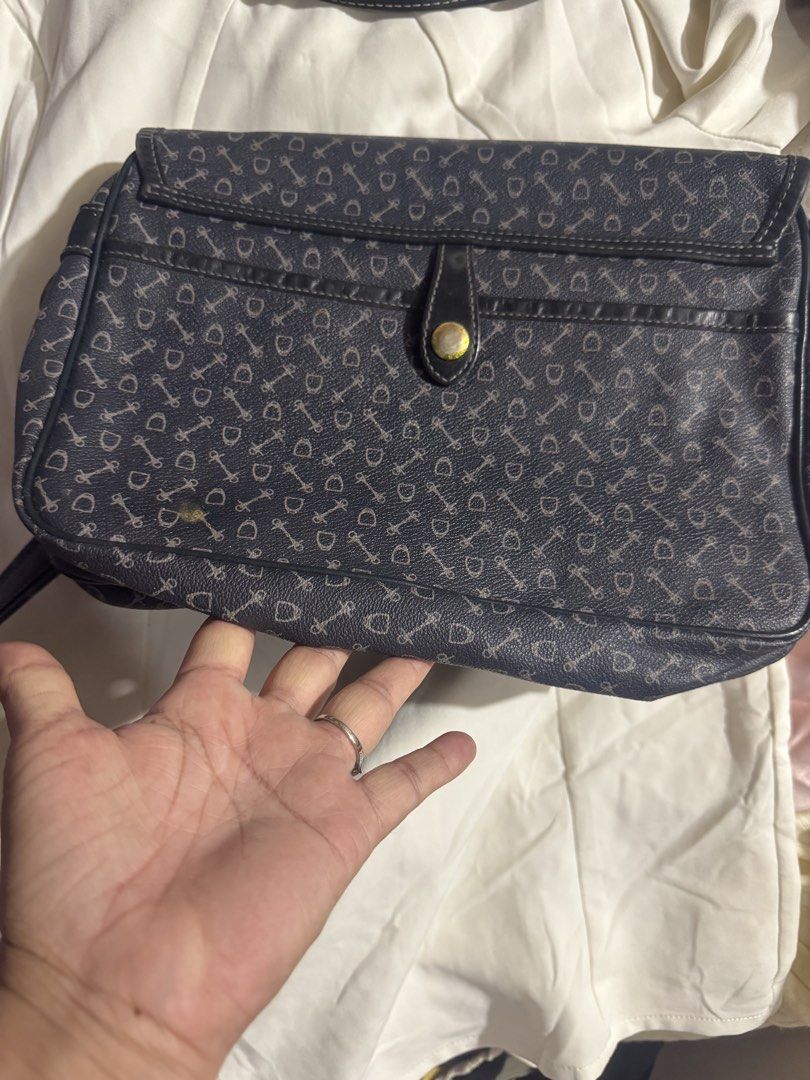 Crossbody bag why 100% leather (Category: Luxury Bags & Wallets) located in Manila. Submitted by wildbear.e10374 (Listing ID 1464735565, Image 2). Description: - Color/Design: Dark blue with allover horsebit print - Hardware: Brass tone with matching hanging debossed leather tag - Closure: Secure flap with snap buttons - Strap: Adjustable for custom fit - Interior: Fabric lining, zippered pocket, and inner gold branding plate - Condition: Minor w