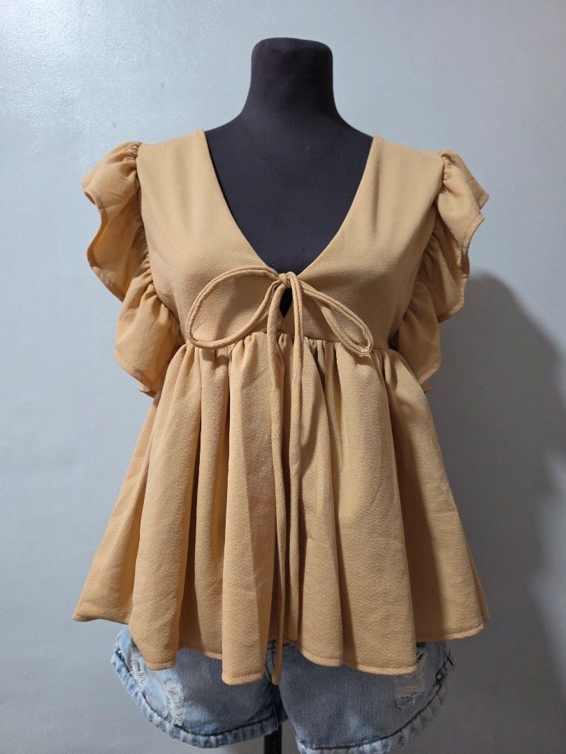 Cute Beige Ruffle Wrap Top with Tie Detail medium (Category: Blouses) located in Paranaque City. Submitted by franinnashop (Listing ID 1464639454, Image 1). Description: - Chic beige top - Ruffled sleeves and neckline - Adjustable front tie for a cinched waist - Flowy, gathered hem - Versatile for pairing with jeans or shorts - Comfortable and stylish for casual outings declutter medium to large paranque city.