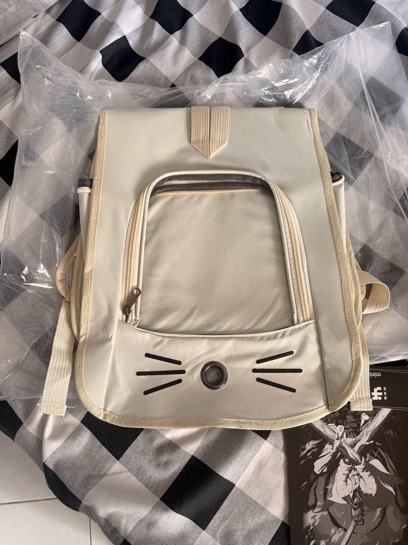 Cute Cat Face Pet Carrier Backpack for Small Animals (Category: Backpacks) located in Manila. Submitted by ellede32655 (Listing ID 1464618790, Image 2). Description: - Cream-colored pet carrier backpack - Features a clear front window with a cute cat face design - Zips open for easy pet access - Adjustable straps for comfortable carrying - Ideal for small pets on the go - Approximately 13 inches tall.