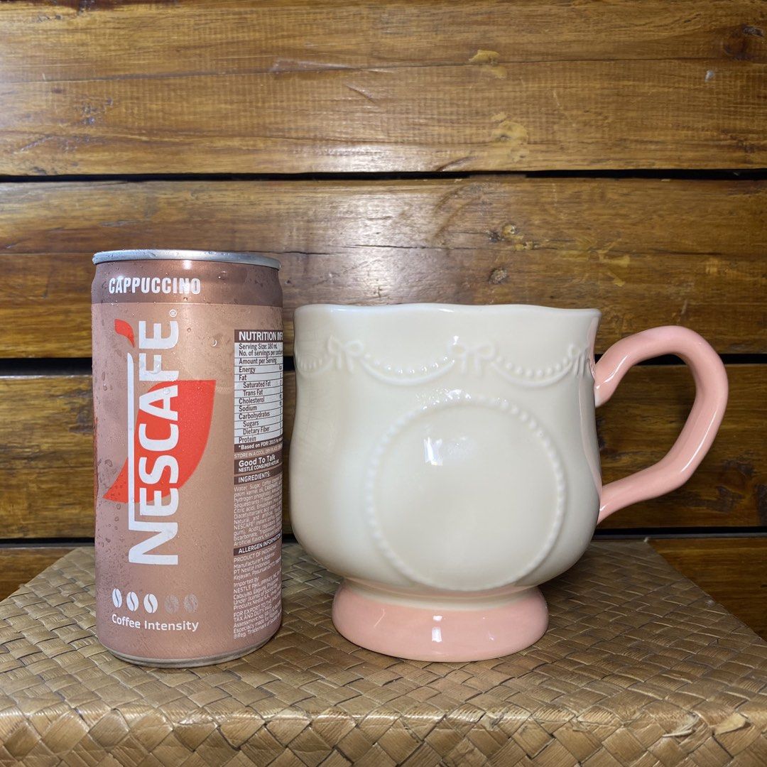 Cute Pink Ceramic Mug (Category: Coffee & Tea Tableware) located in Quezon City. Submitted by oliviararo46032 (Listing ID 1464673593, Image 2). Description: - Adorable white ceramic mug - Features a lovely embossed ribbon and circle design - Soft pink handle and base - Perfect for coffee or tea - Makes a great gift - Approximately 4 inches tall.