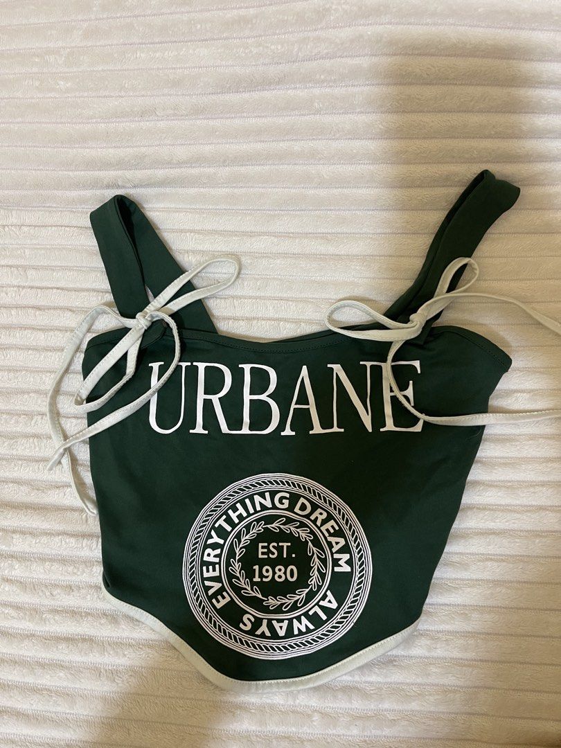 Dark Green Graphic Corset Crop Top (Category: Others Tops) located in Manila. Submitted by rare.yurichi (Listing ID 1464738218, Image 1). Description: Deep forest green top featuring white “URBANE” text and a circular “Dream Everything Always EST. 1980” graphic emblem. Designed with a curved corset-style pointed hem, contrasting white trim, and adjustable shoulder tie straps..
