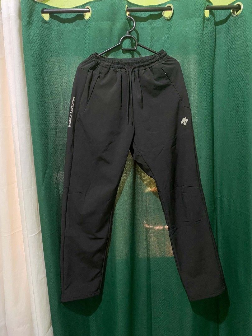 Descente Running Black Track Pants Men's Size L (Category: Joggers) located in Quezon City. Submitted by elihur.tuazon (Listing ID 1464736822, Image 1). Description: - Brand: Descente Running - Color: Black - Size: Men's L (Relaxed fit) - Waistband: Elastic with adjustable drawstring cords - Pockets: Secure zipped pockets on both sides - Details: Descente logo on left thigh and DESCENTE RUNNING text down the right leg - Interior: Soft fleece lini