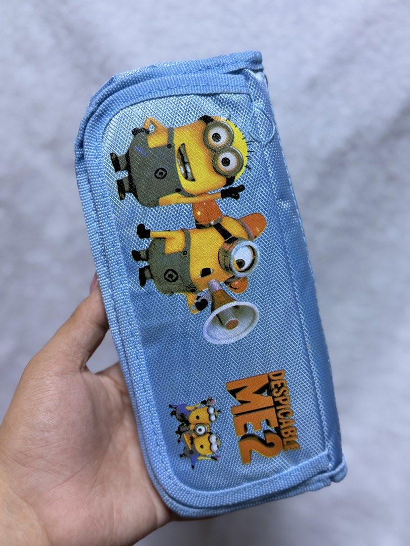 Despicable Me 2 Minions Blue Pencil Case Pouch (Category: Purses & Pouches) located in Baguio. Submitted by aalkharys (Listing ID 1464739248, Image 2). Description: - Authentic Despicable Me 2 Minions graphics - Color: Light blue - Secure top zipper closure - Clean fabric interior with a small velcro pocket - Brand new in original plastic packaging.