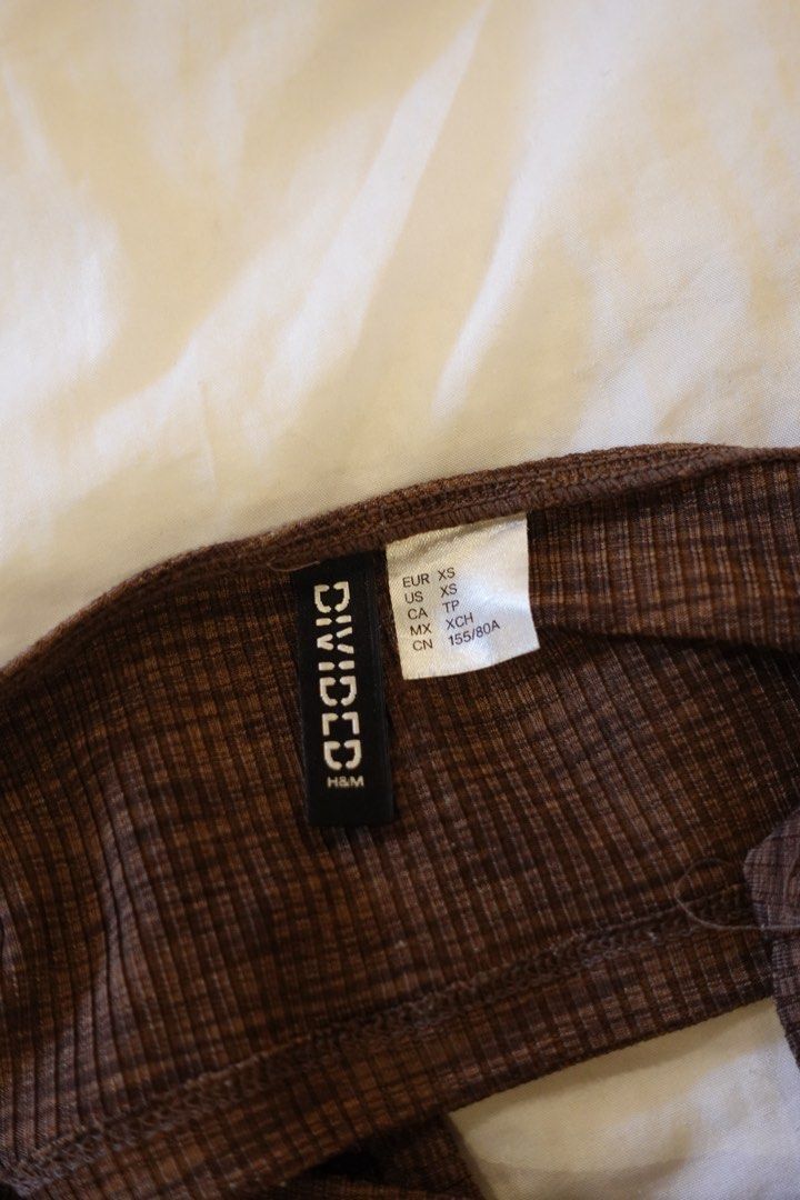 Divided H&M Brown Ribbed Halter Top XS (Category: Sleeveless) located in Pasig City. Submitted by hulyascloset (Listing ID 1464620406, Image 2). Description: - Brand: Divided by H&M - Color: Brown - Style: Ribbed Halter Top - Size: XS - Features: Subtle checkered texture, ties at the neck - Versatility: Perfect for layering or wearing on its own.