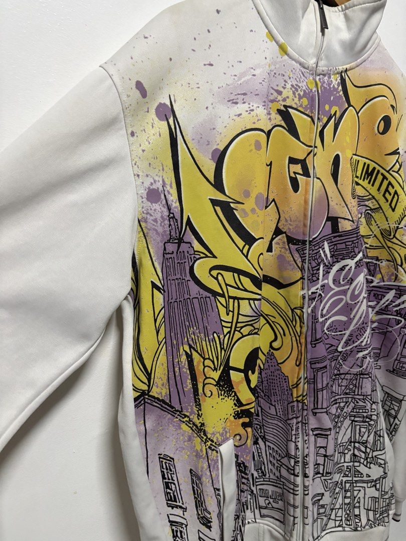 Ecko Unltd Full Zip Graffiti Print Track Jacket XL (Category: Coats, Jackets and Outerwear) located in Manila. Submitted by skeletal_v2 (Listing ID 1464743585, Image 2). Description: ECKO UNLTD- AOP GRAFFITI NEW YOUR 5000+SF 26/32 GOOD CONDITION COLOR RATE 9.2/10 - Brand: Ecko Unltd - Size: XL - Color: White with yellow and purple graffiti street art graphics - Details: Full zip, mock neck with black interior lining, front pockets, ribbed cuffs w
