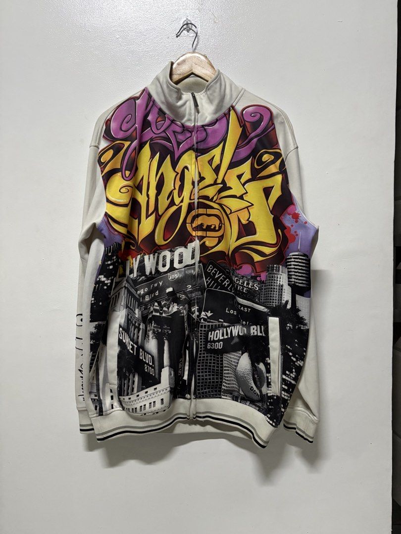 Ecko Unltd. Los Angeles Graffiti Full Zip Track Jacket (Category: Coats, Jackets and Outerwear) located in Manila. Submitted by skeletal_v2 (Listing ID 1464743676, Image 1). Description: ECKO UNLTD- AOP GRAFFITI WRITING ALL WRONGS 6500+SF 24/30 GOOD CONDITION COLOR RATE 9.2/10 STAIN Ecko Unltd. full zip track jacket. Cream base colour with striking Los Angeles graffiti print across the upper chest and monochrome street photography collage on the 
