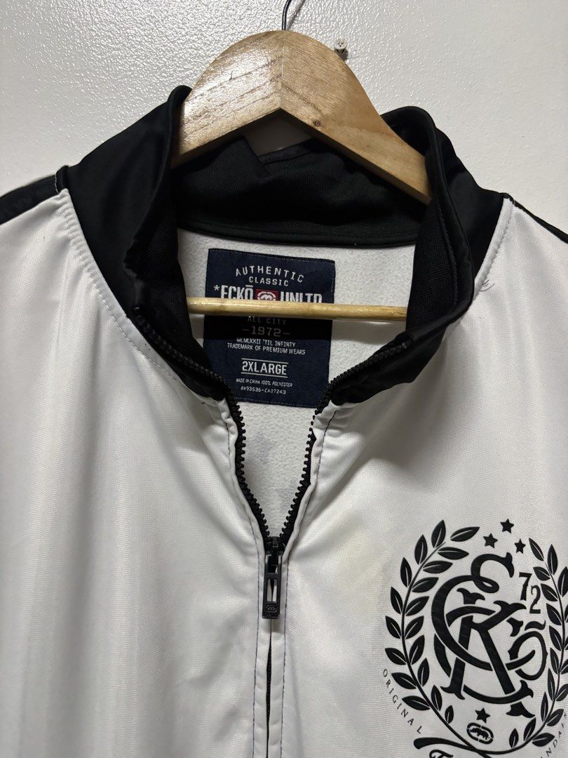 Ecko Unltd Track Jacket White Black Size 2XL (Category: Coats, Jackets and Outerwear) located in Manila. Submitted by skeletal_v2 (Listing ID 1464743269, Image 3). Description: ECKO UNLTD- 1000+SF 25/30 GOOD CONDITION COLOR RATE 9/10 STAIN - Brand: Ecko Unltd - Style: Full-zip track jacket - Color: White and black with contrast stripes - Size: Tagged 2XL - Material: 100% polyester - Features: Stand-up collar, side pockets, bold printed graphic lo
