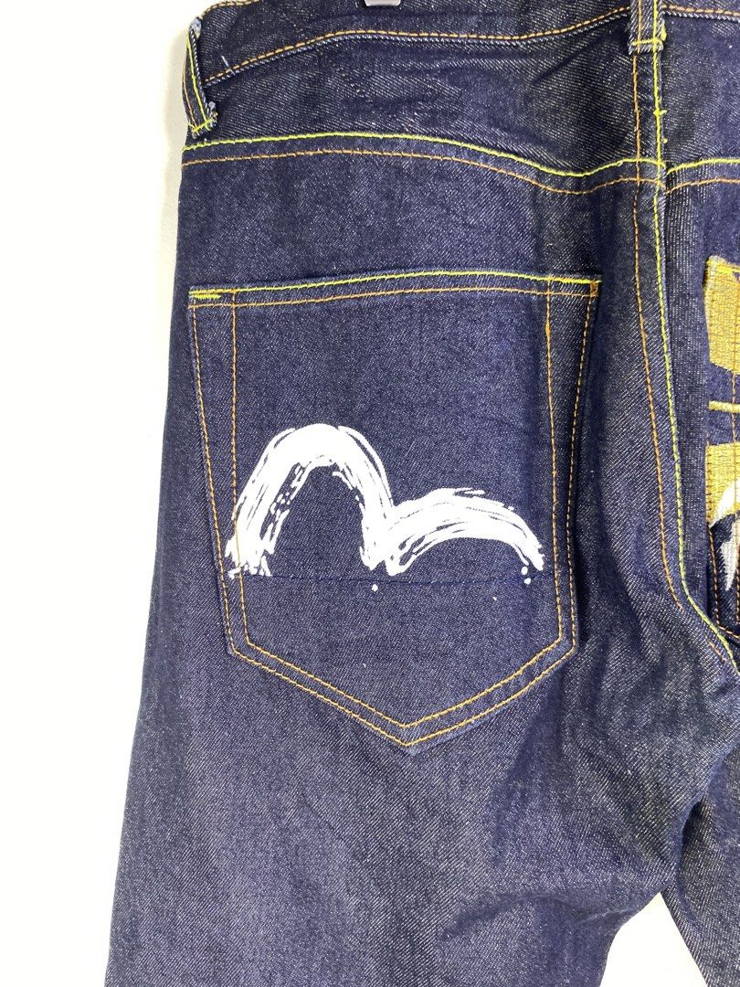 Evisu Heritage Denim Jeans (Category: Jeans) located in Manila. Submitted by declutterpromax (Listing ID 1464601132, Image 3). Description: - Dark wash Evisu Heritage jeans - Iconic Evisu logo on one back pocket - Japanese mountain and sun graphic on the other back pocket - Yellow stitching throughout - Classic five-pocket styling - Button fly closure.
