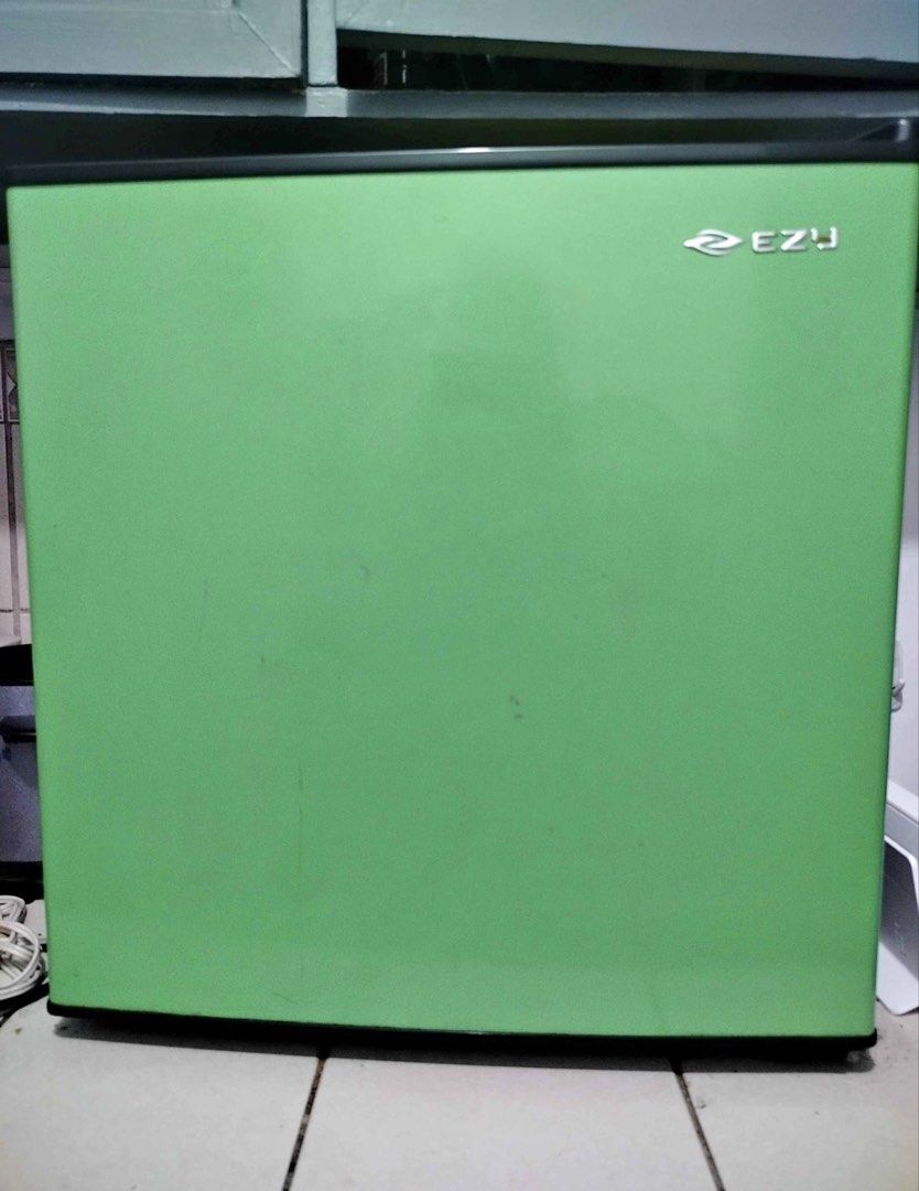 EZY Mini Fridge Green (Category: Refrigerators and Freezers) located in Batangas. Submitted by shibriones (Listing ID 1464589486, Image 1). Description: - Compact mini fridge in a cute green color - Ideal for dorm rooms, bedrooms, or office spaces - Fully functional and works well - Includes an interior shelf and a top compartment - Door offers convenient storage for small items - Interior is clean and well-maintained - Minor cosmetic scuffs on t