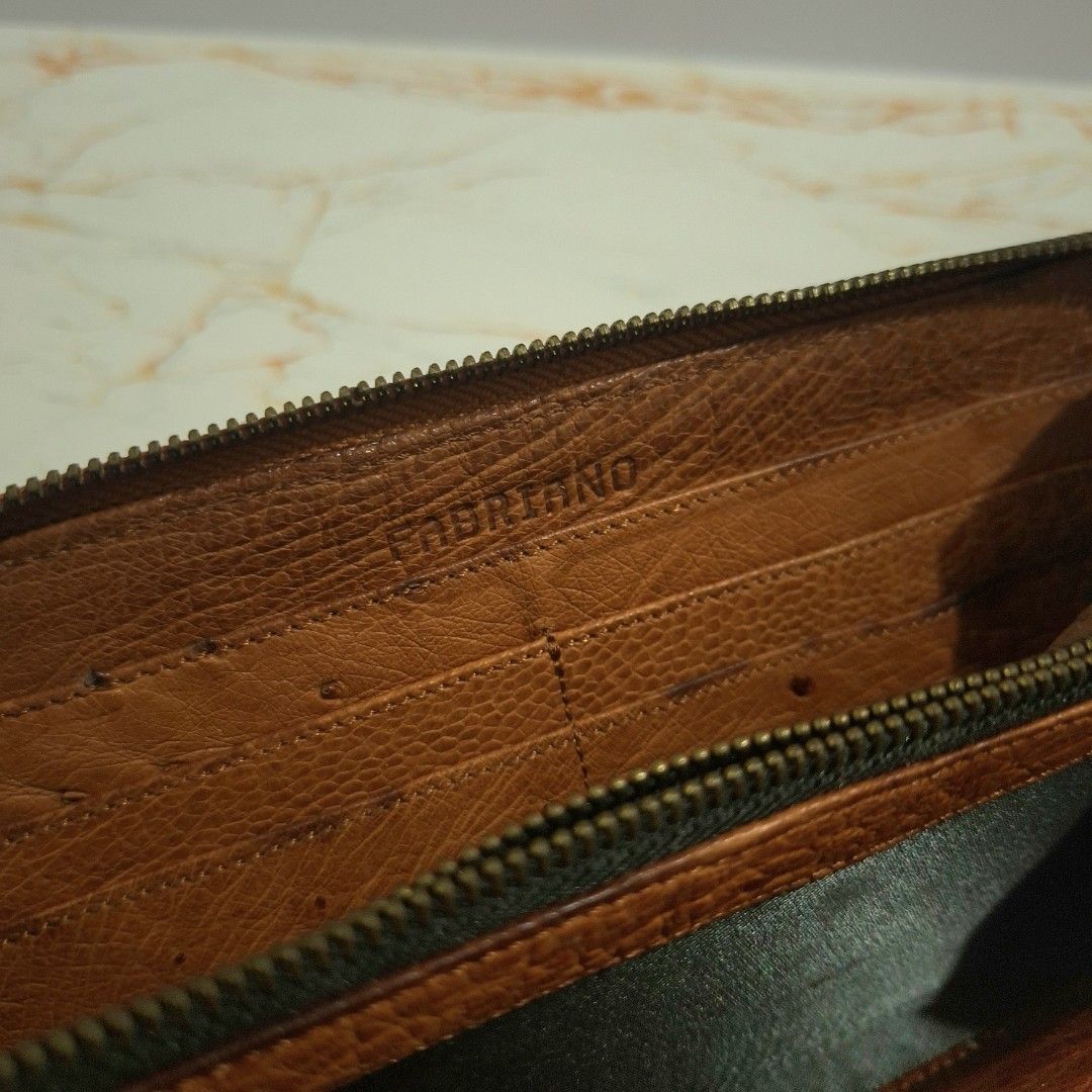 Fabriano Brown Leather Zip Around Long Wallet (Category: Wallets & Card holders) located in Baguio. Submitted by marjshane11317 (Listing ID 1464734943, Image 2). Description: - Brand: Fabriano - Material: Brown textured ostrich leather - Closure: Secure zip-around - Interior: Multiple card slots, slip pockets, and a center zippered coin compartment - Size: Approximately 19 cm across - Condition: Normal wear on leather and hardware; all zippers ru