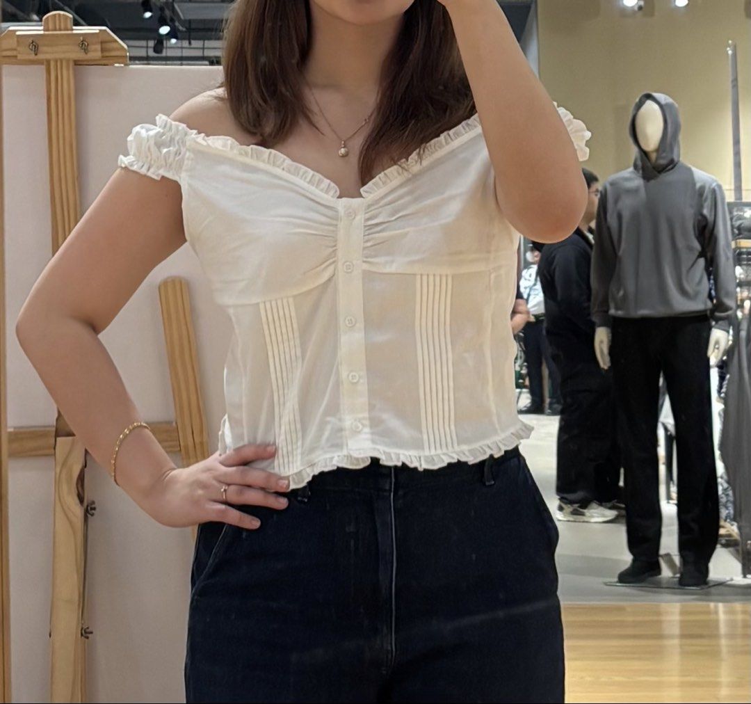FACTORIE White Ruffle Button Up Top Size M (Category: Blouses) located in Cainta. Submitted by kairus.luckyfind (Listing ID 1464644885, Image 1). Description: swipe for ww pics - Cute white top from Factorie - Features ruffles around the neckline and sleeves - Button-up front with gathering detail - Versatile for pairing with jeans or shorts - Ideal for casual outings.