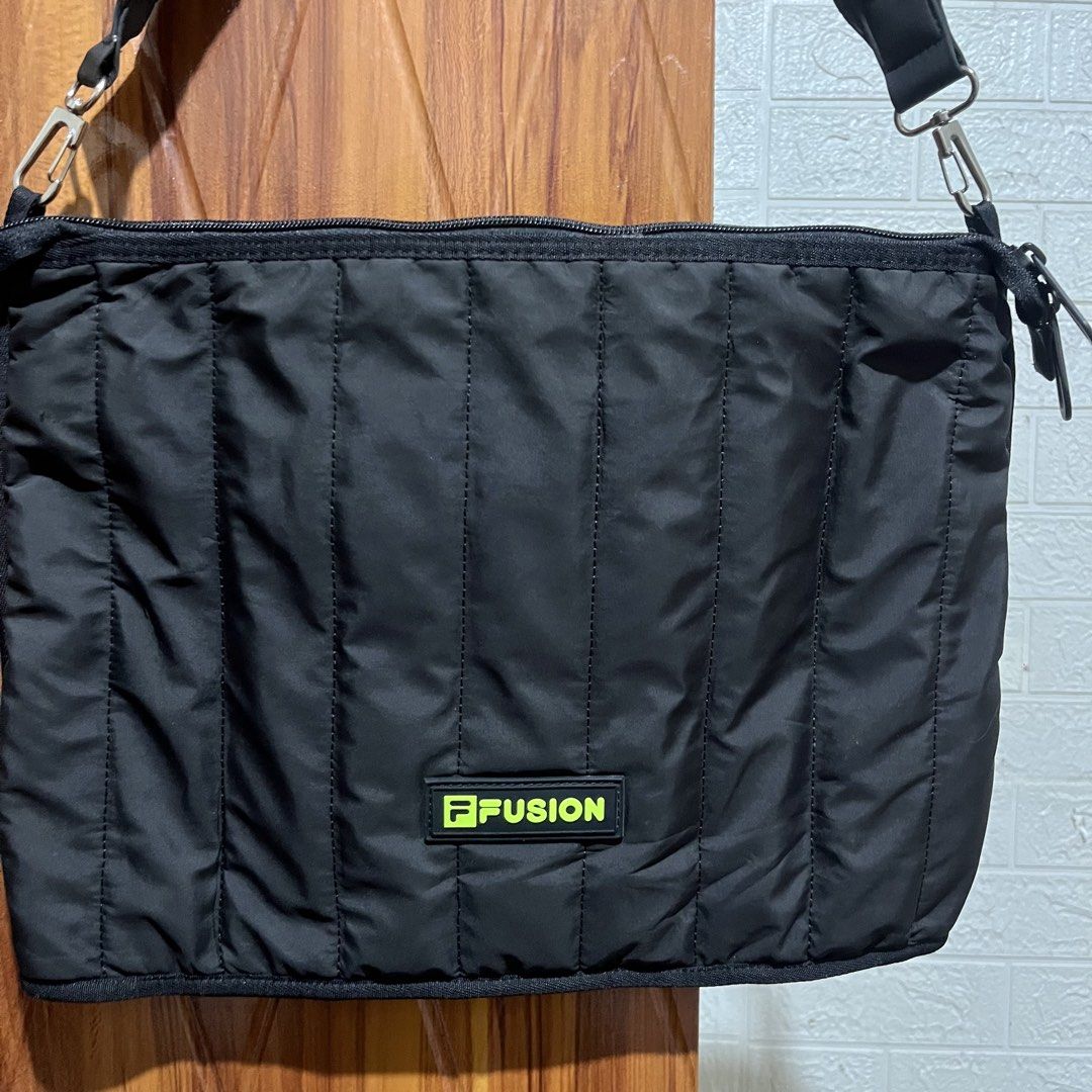 FILA Fusion Puffer Black Shoulder Bag (Category: Shoulder Bags) located in Carmen. Submitted by rr_thrifts (Listing ID 1464728284, Image 2). Description: - Brand: FILA Fusion - Color: Black with neon green logo patch - Material/Design: Quilted puffer design throughout - Strap: Chunky padded strap with silver-tone metal hardware and clips - Closure: Dual zipper closure with FILA branded pulls - Interior: Clean lining with an open slip pocket insid