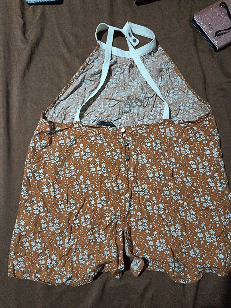 Floral Halter Neck Romper (Category: Rompers) located in Manila. Submitted by xoesnup1 (Listing ID 1464736844, Image 2). Description: - Brand: Intermax - Style: Brown romper with all-over white floral print - Details: Halter neck with white straps, front button-down closure - Material: Lightweight and breathable - Condition: Excellent / Like new - Perfect for: Casual day outs, beach trips, and warm weather.