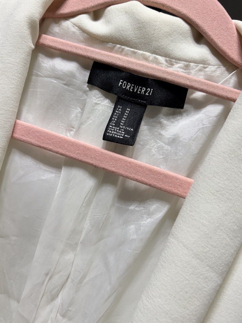Forever 21 White Longline Blazer Size M (Category: Coats, Jackets and Outerwear) located in Manila. Submitted by finderskeepersmnl_092026 (Listing ID 1464746089, Image 2). Description: - Brand: Forever 21 - Size: Medium - Color: Classic White - Design: Shawl lapel with a single-button front closure - Features: Fully lined interior and two functional front pockets - Fit: Clean, structured silhouette - Versatility: Ideal for corporate workwear or s
