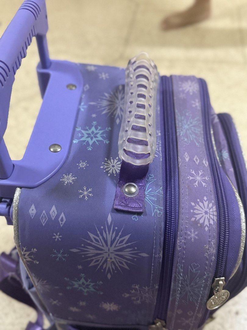 Frozen trolly school bag (Category: Backpacks) located in Bocaue. Submitted by cocro_crafts (Listing ID 1464571413, Image 3). Description: - Features Elsa and Anna from Disney's Frozen with a 'Forever Sisters' graphic. - Versatile design with wheels, a retractable handle, and adjustable shoulder straps. - Includes side mesh pockets for easy access to water bottles. - Ideal for school, day trips, or travel adventures. - See picture for flaws .