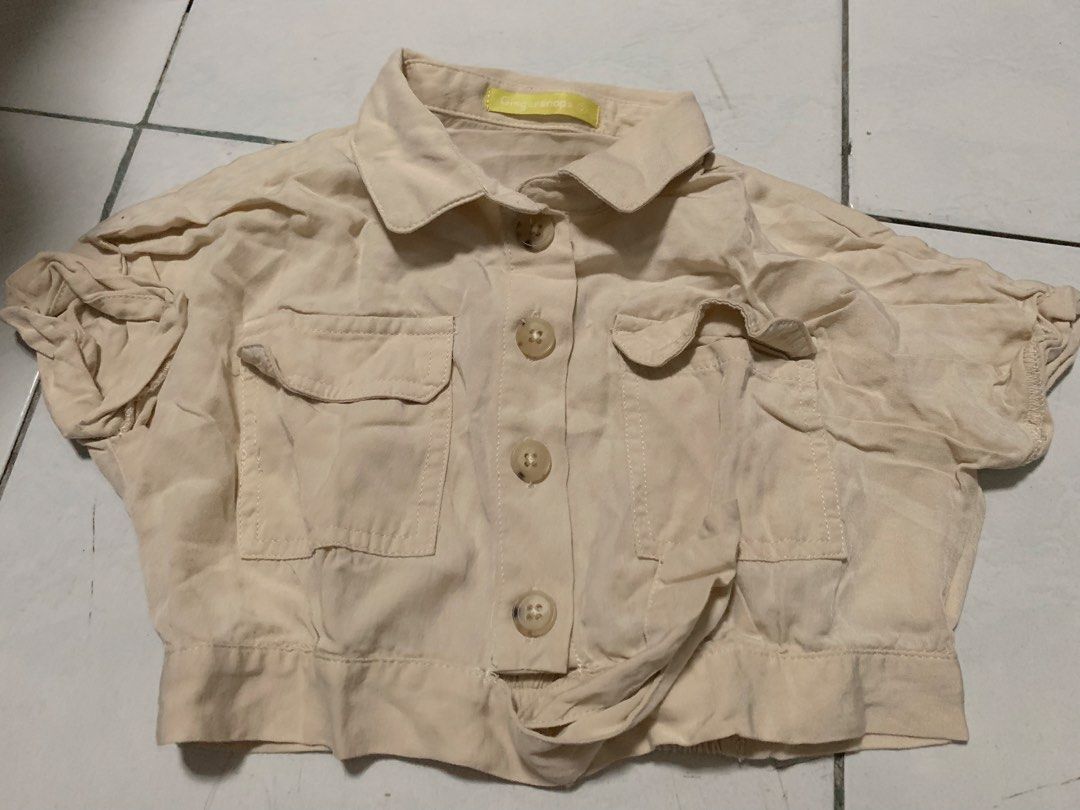 Gingersnaps Beige Cropped Jacket Size 2 (Category: Coats, Jackets and Outerwear) located in Malabon City. Submitted by vewonica (Listing ID 1464610132, Image 1). Description: - Beige cropped jacket from Gingersnaps - Size: Approximately 2 - Features: Collar, button-up front, two chest pockets with button closures - Design: Elasticated hem and short sleeves with elastic cuffs - Style: Great for layering.