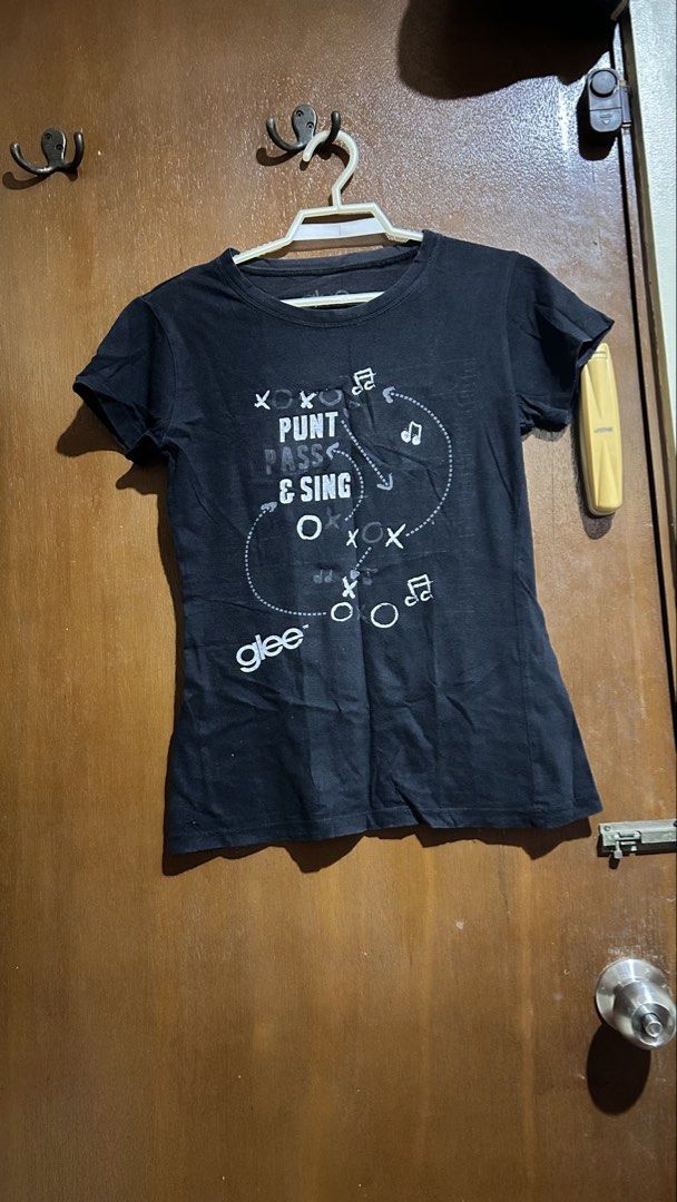 Glee Punt Pass & Sing Black T-Shirt (Category: Shirts) located in Cabuyao City. Submitted by pickedbyarya (Listing ID 1464749628, Image 1). Description: Size XS-S W 15 x L 21 in Comfy fit - Authentic Glee merchandise with 'Punt Pass & Sing' graphic - Color: Black with musical notes and X/O symbols - Fit: Fitted cut, crew neck, short sleeves - Material: Comfortable cotton - Condition: with inner Glee logo tag - Perfect casual tee for TV show and m
