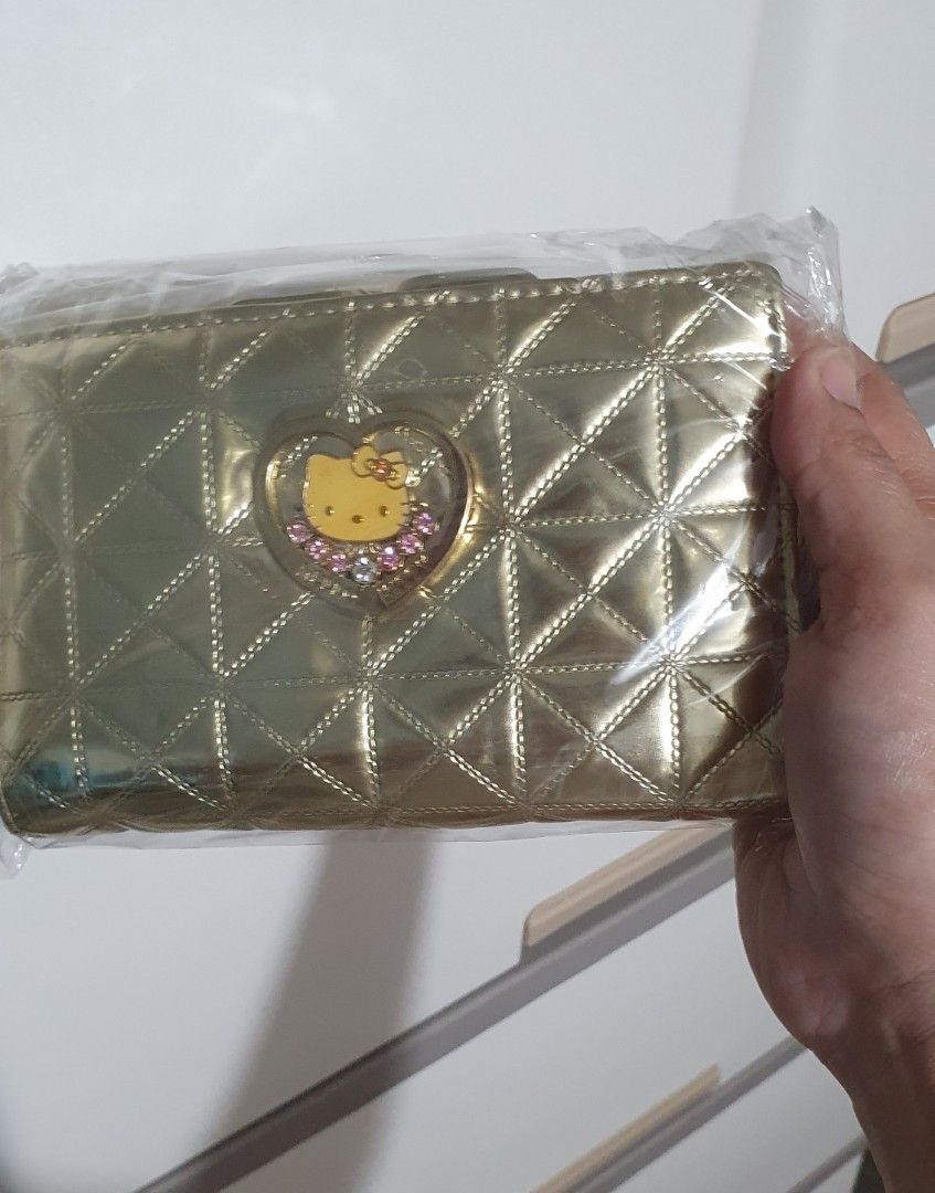 Gold Hello Kitty Quilted Wallet with Ribbon Closure (Category: Wallets & Card holders) located in Marilao. Submitted by majoriety (Listing ID 1464740250, Image 1). Description: - Brand new, still sealed in original plastic packaging - Chic gold quilted design with diamond pattern - Features a sparkly rhinestone heart Kitty accent - Cute gold ribbon clasp closure on the back - Compact and useful everyday organizer for cards, cash, and coins.