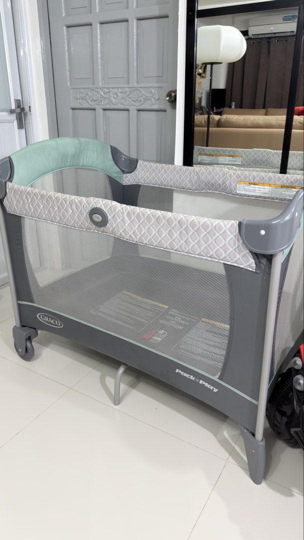 Graco Pack 'n Play Playard (Category: Cots & Cribs) located in Cavite. Submitted by fashyph (Listing ID 1464756109, Image 1). Description: Graco Pack 'n Play playard in grey and sage green. Includes the folding mattress pad with warning labels and safety straps attached. Mesh sides for breathability and wheels on one side for easy moving around the room. Packs down simply for travel or storage. Unused, infant cot Issue: water marks from washing o