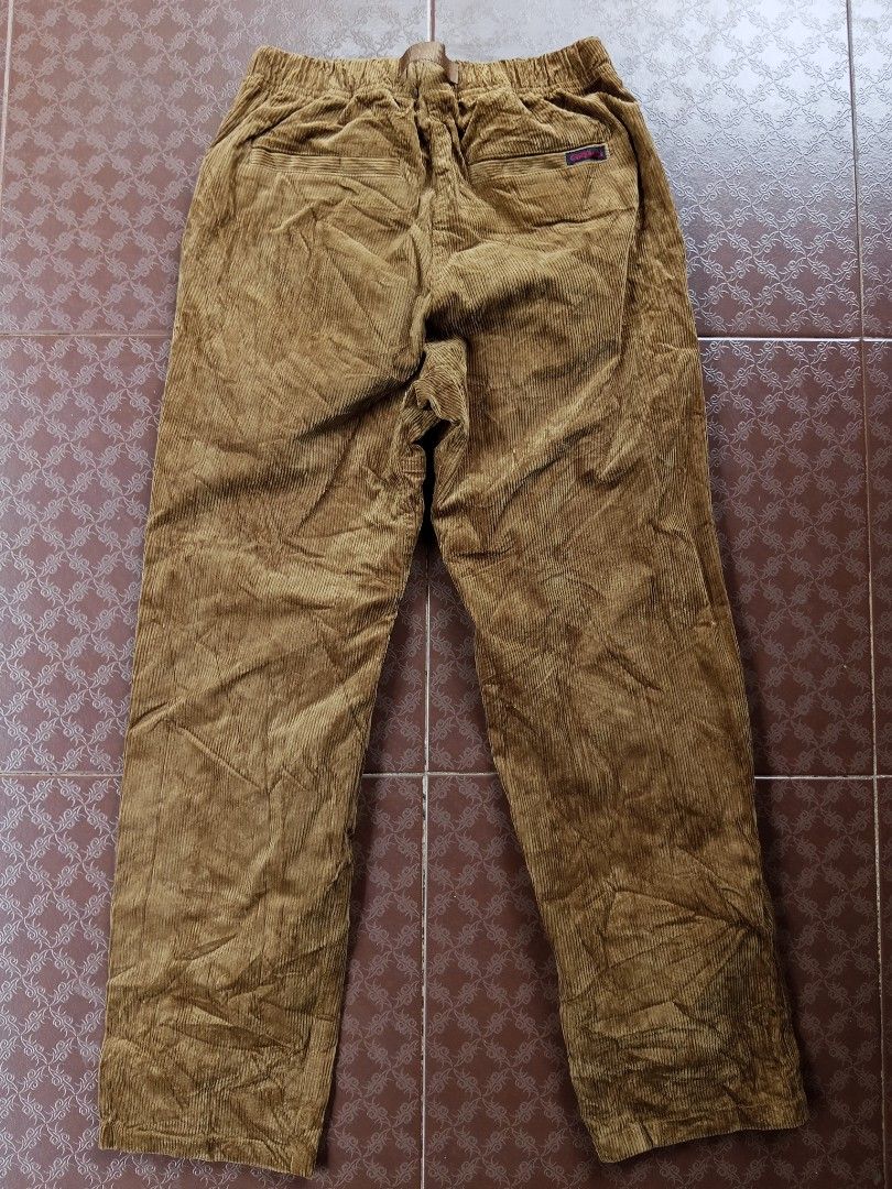 Gramicci Corduroy Pants (Category: Trousers) located in Davao. Submitted by carnopaul76938 (Listing ID 1464709319, Image 2). Description: - Brand: Gramicci - Color: Rich camel brown - Material: Textured corduroy rib fabric for warmth - Fit: Classic relaxed fit with elastic waistband - Features: Built-in adjustable nylon webbing belt with quick-release buckle and running man logo - Pockets: Dual rear welt pockets with branded woven label - Style: 