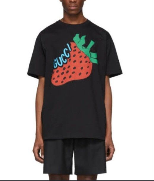 Gucci🍓 🖤TeeShirt (Category: Luxury Apparel) located in Navotas City. Submitted by ms.soulana (Listing ID 1464693483, Image 2). Description: PreOwned Lightly Used Gucci Strwberry Printed black TeeShirt -Medium - Color: Black - Design: Large red strawberry graphic with green stem and blue Gucci logo lettering - Fit: Standard fit - Details: Crew neckline, short sleeves, solid black back - Condition: Clean and well-maintained - Style: Casual design
