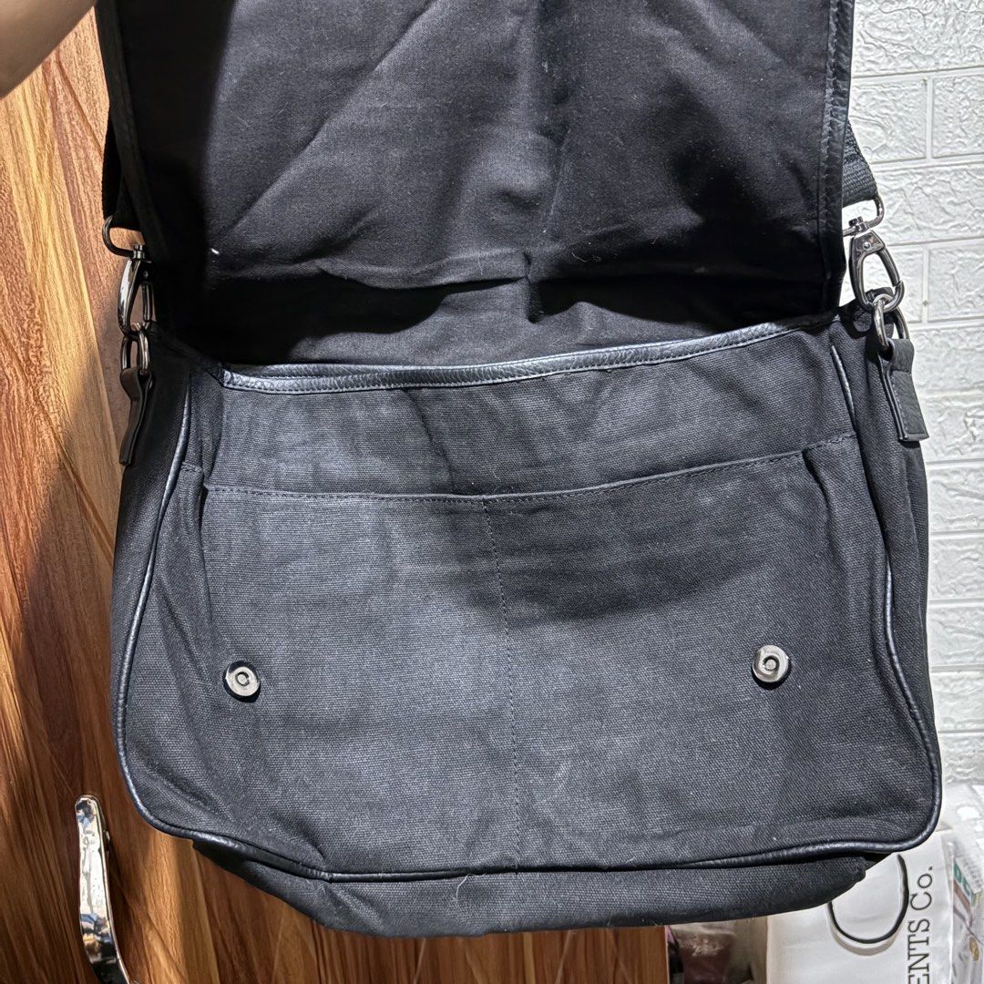 Guess Black Canvas Messenger Bag (Category: Sling Bags) located in Carmen. Submitted by rr_thrifts (Listing ID 1464721790, Image 3). Description: - Brand: Guess - Material: Durable black canvas - Design: Large grey GUESS logo on front flap - Closure: Double magnetic snap buttons - Strap: Adjustable black strap with metal swivel clips - Interior: Zip pocket and multi-slot compartments with clean black lining - Use: Spacious everyday bag, ideal for