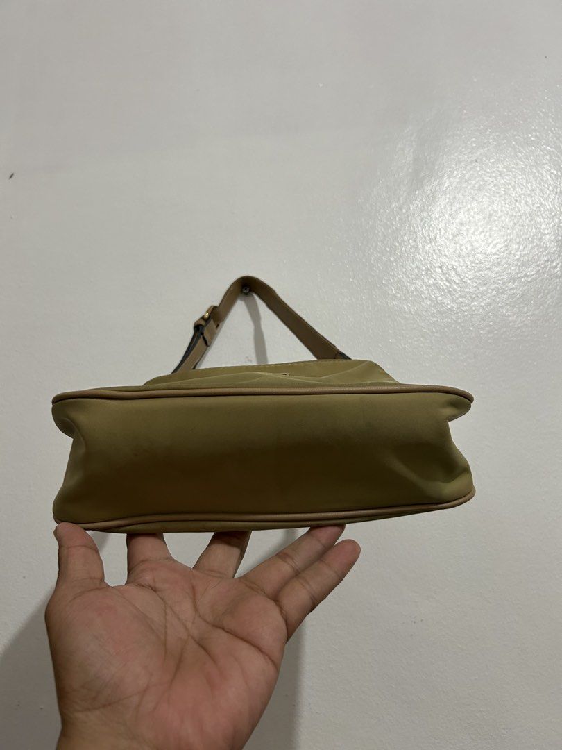 Guess Khaki Nylon Shoulder Bag (Category: Shoulder Bags) located in Angeles City. Submitted by cassey_phoenix (Listing ID 1464707735, Image 3). Description: - Brand: Guess - Color: Khaki olive with tan faux leather trim - Material: Durable nylon body - Hardware: Gold-tone - Logo: Metal triangular Guess USA plaque on the front - Closure: Zip top closure - Interior: Branded fabric lining with one zippered pocket - Strap: Adjustable - Condition: Cle