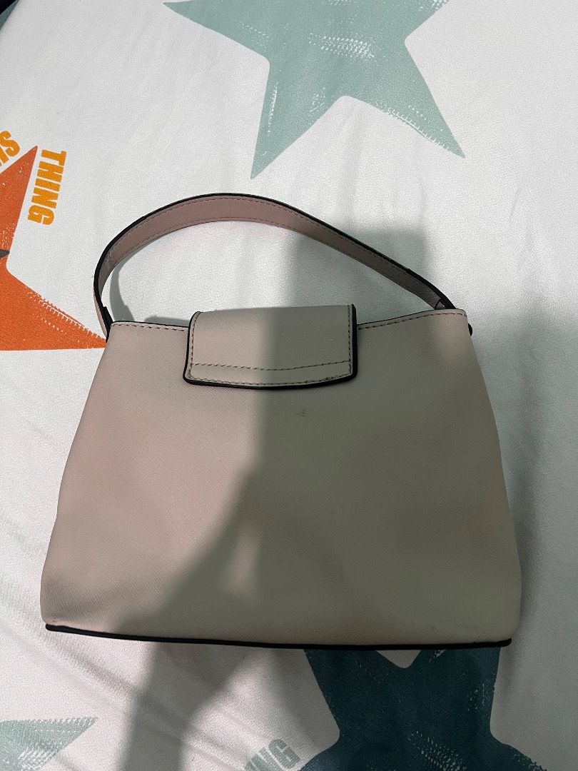 Guess Roseburg Small Satchel (Clay) (Category: Purses & Pouches) located in Consolacion. Submitted by hann_m_m (Listing ID 1464760022, Image 2). Description: Brand/Model: Guess Roseburg Small Satchel Color: Clay (dusty pink/beige neutral shade) Design: Structured small handbag featuring a prominent ornate 'G' logo on the front flap Handle: Sturdy single top handle for easy carrying Interior: Fully lined with a secure zippered pocket and slip comp