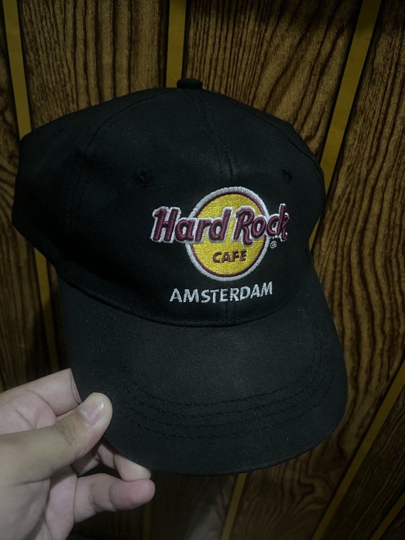 Hard Rock Cafe Amsterdam Black Baseball Cap (Category: Caps & Hats) located in Manila. Submitted by dwyaneallen (Listing ID 1464679832, Image 1). Description: - Hard Rock Cafe Amsterdam Baseball Cap - Color: Black - Material: 100% Cotton - Features embroidered Hard Rock Cafe logo and 'Amsterdam' text on the front - Adjustable strap with metal buckle for a custom fit - Ideal for casual everyday wear.