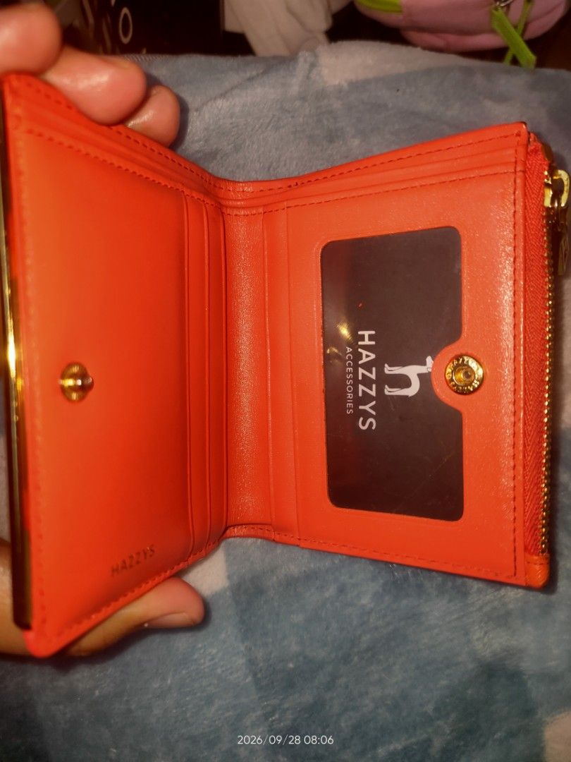Hazzys Leather Bifold Wallet with Zipper (Category: Wallets & Card holders) located in Los Banos. Submitted by tritrollse.04 (Listing ID 1464571105, Image 3). Description: - Brand: Hazzys - Color: Orange red - Style: Bifold Wallet - Material: Textured Leather - Features: Side zippered compartment, interior card slots, clear ID window - Hardware: Gold details - Size: Small and compact, easy to carry - flaws: Signs of usage , slight color transfers