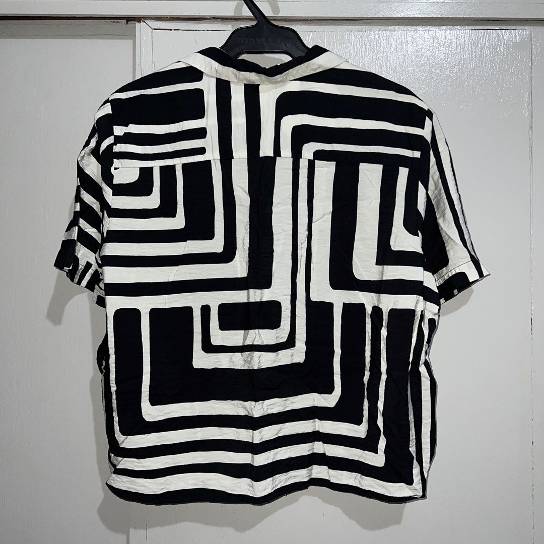 H&M Black and White Cropped Polo (Category: Shirts) located in Makati City. Submitted by b5closet (Listing ID 1464649664, Image 2). Description: - H&M Black and White Cropped Polo - Size M - Length: 22 inches - Width: 21 inches - Cool geometric print - Short sleeves - Button-up front - Versatile for casual styling with jeans or shorts NOTE: - Condition: Excellent ‼️ - Minimal usage ‼️ - GCASH and BDO MOP - SF will be shouldered by buyer.