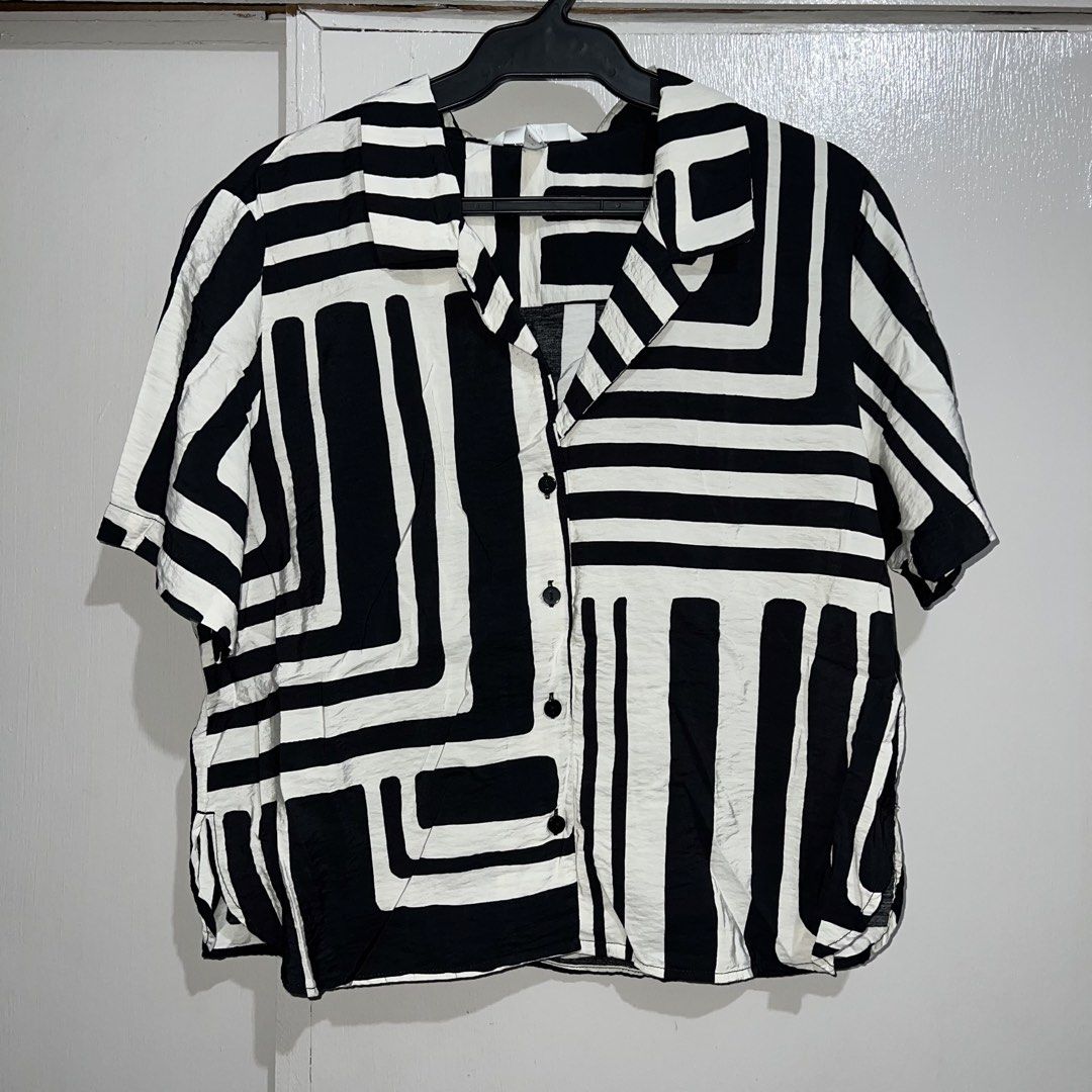 H&M Black and White Cropped Polo (Category: Shirts) located in Makati City. Submitted by b5closet (Listing ID 1464649664, Image 1). Description: - H&M Black and White Cropped Polo - Size M - Length: 22 inches - Width: 21 inches - Cool geometric print - Short sleeves - Button-up front - Versatile for casual styling with jeans or shorts NOTE: - Condition: Excellent ‼️ - Minimal usage ‼️ - GCASH and BDO MOP - SF will be shouldered by buyer.