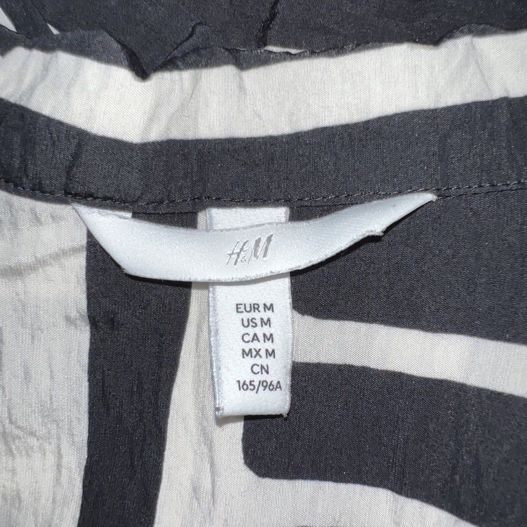 H&M Black and White Cropped Polo (Category: Shirts) located in Makati City. Submitted by b5closet (Listing ID 1464649664, Image 3). Description: - H&M Black and White Cropped Polo - Size M - Length: 22 inches - Width: 21 inches - Cool geometric print - Short sleeves - Button-up front - Versatile for casual styling with jeans or shorts NOTE: - Condition: Excellent ‼️ - Minimal usage ‼️ - GCASH and BDO MOP - SF will be shouldered by buyer.