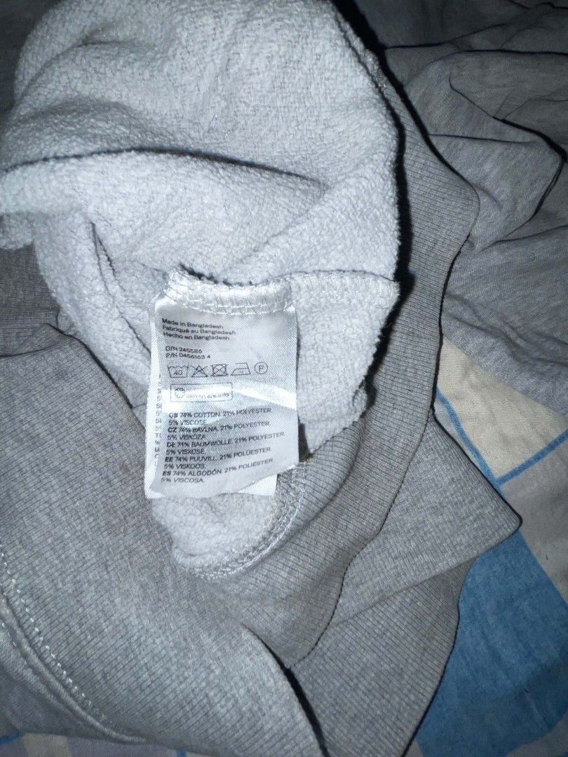 H&M Grey Hoodie Boxy Type (Category: Coats, Jackets and Outerwear) located in Manila. Submitted by joshthrifts (Listing ID 1464702824, Image 3). Description: - Brand: H&M - Size: Small (Regular fit) - Color: Grey - Material: Cotton, polyester, and viscose blend - Features: Front kangaroo pocket, adjustable white drawstrings - Condition: Pre-loved with visible wear and staining on the fabric and cuffs - Style: Classic casual wear.