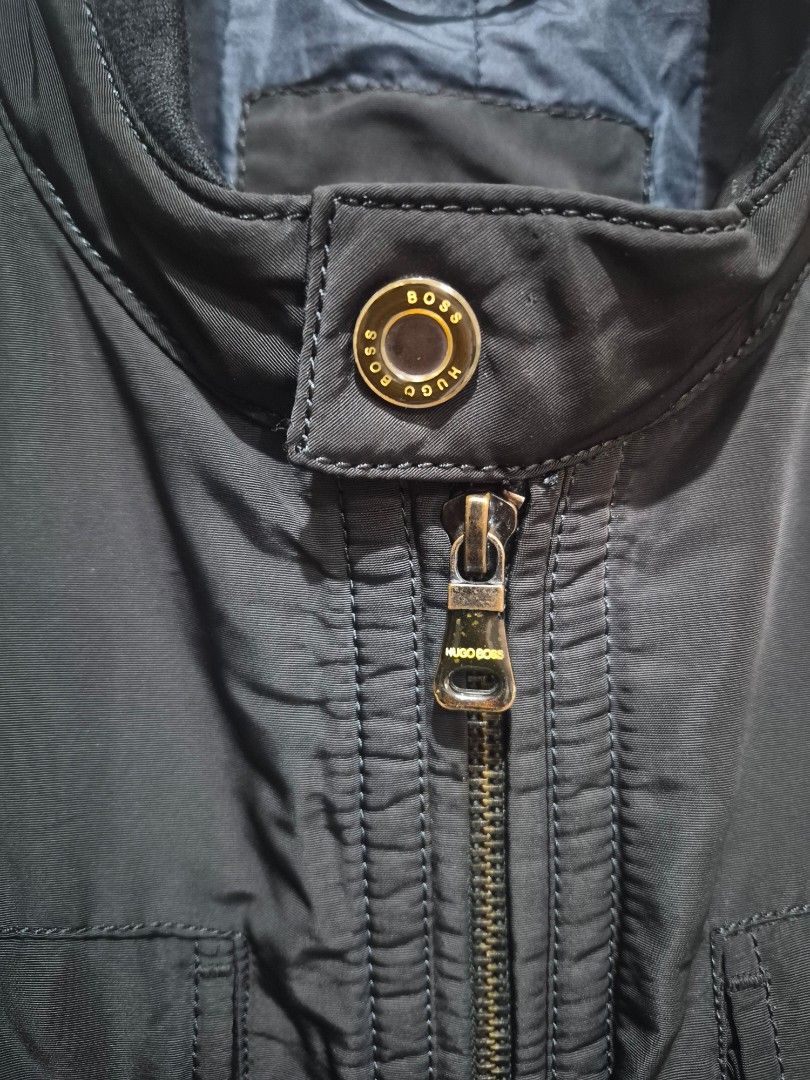 Hugo Boss Black Winter Jacket Outerwear (Category: Coats, Jackets and Outerwear) located in Bulacan. Submitted by vince4593 (Listing ID 1464712829, Image 3). Description: - Authentic Hugo Boss black winter jacket - Heavyweight and very warm construction - Full front zipper with branded metal hardware and snap buttons - Multiple front utility pockets with flap closures and zippers - Stylish high collar design - Padded quilted dark blue interior li