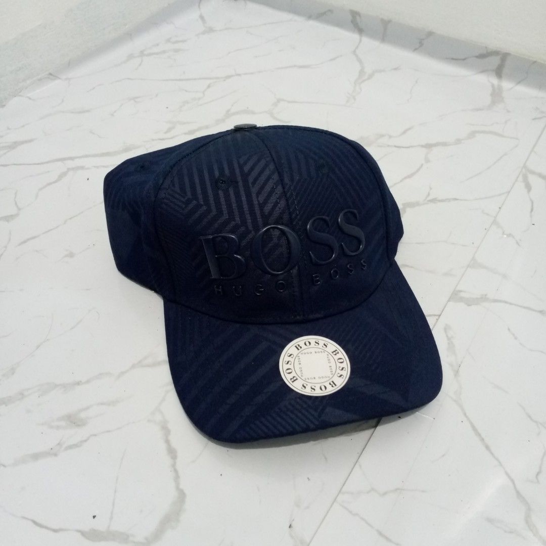 Hugo Boss Navy Blue Geometric Print Baseball Cap (Category: Caps & Hats) located in Manila. Submitted by pablopresk0. (Listing ID 1464741592, Image 1). Description: - Brand: Hugo Boss - Color: Dark blue with all-over geometric pattern - Logo: Raised embroidered BOSS lettering on front - Fit: Adjustable strap at the back - Condition: Brand new with green inner tag, original cardboard insert, and plastic-wrapped badge Manila location📍 Excellent Co