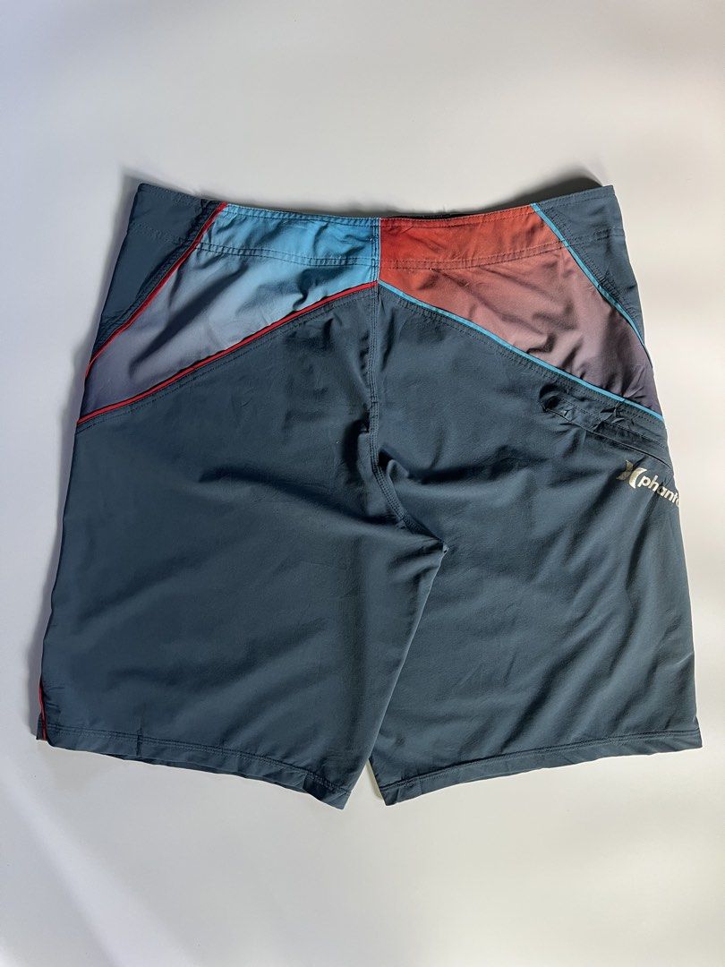 Hurley Phantom Board Shorts Swim Trunks (Category: Swim Trunks & Board Shorts) located in Baler. Submitted by allthrifted31 (Listing ID 1464732102, Image 2). Description: - Brand: Hurley Phantom - Color: Dark grey with blue and reddish-orange gradient panels - Fabric: Performance stretch, lightweight, and quick-drying - Features: Secure zippered side pocket with logo, adjustable drawstring waist - Condition: Excellent for surfing, swimming, and b