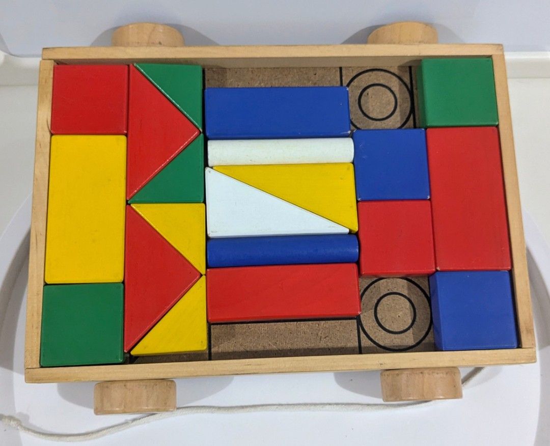 ikea Wooden Pull Toy Wagon with Colored Building Blocks (Category: Educational & Learning Toys) located in Quezon City. Submitted by furbous (Listing ID 1464718212, Image 1). Description: - Classic wooden pull toy cart with rolling wheels and a pull string - Filled with colorful geometric blocks (rectangles, triangles, cylinders) - Bright primary and neutral colors: red, blue, yellow, green, and white - Great educational toy for toddler sorting a