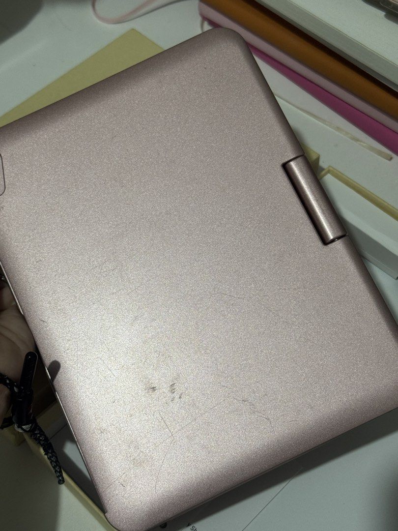 IPAD MINI KEYBOARD CASE (ROSE GOLD) (Category: Cases & Sleeves) located in Las Pinas. Submitted by lesaiah (Listing ID 1464688705, Image 3). Description: - Model: Rose gold iPad Mini keyboard case with clamshell design - Features: Built-in trackpad, white keys in standard layout, Bluetooth connectivity - Condition: Fully functional, with some surface scratches and wear marks on the exterior shell from daily carrying - Inclusions: Comes with the o