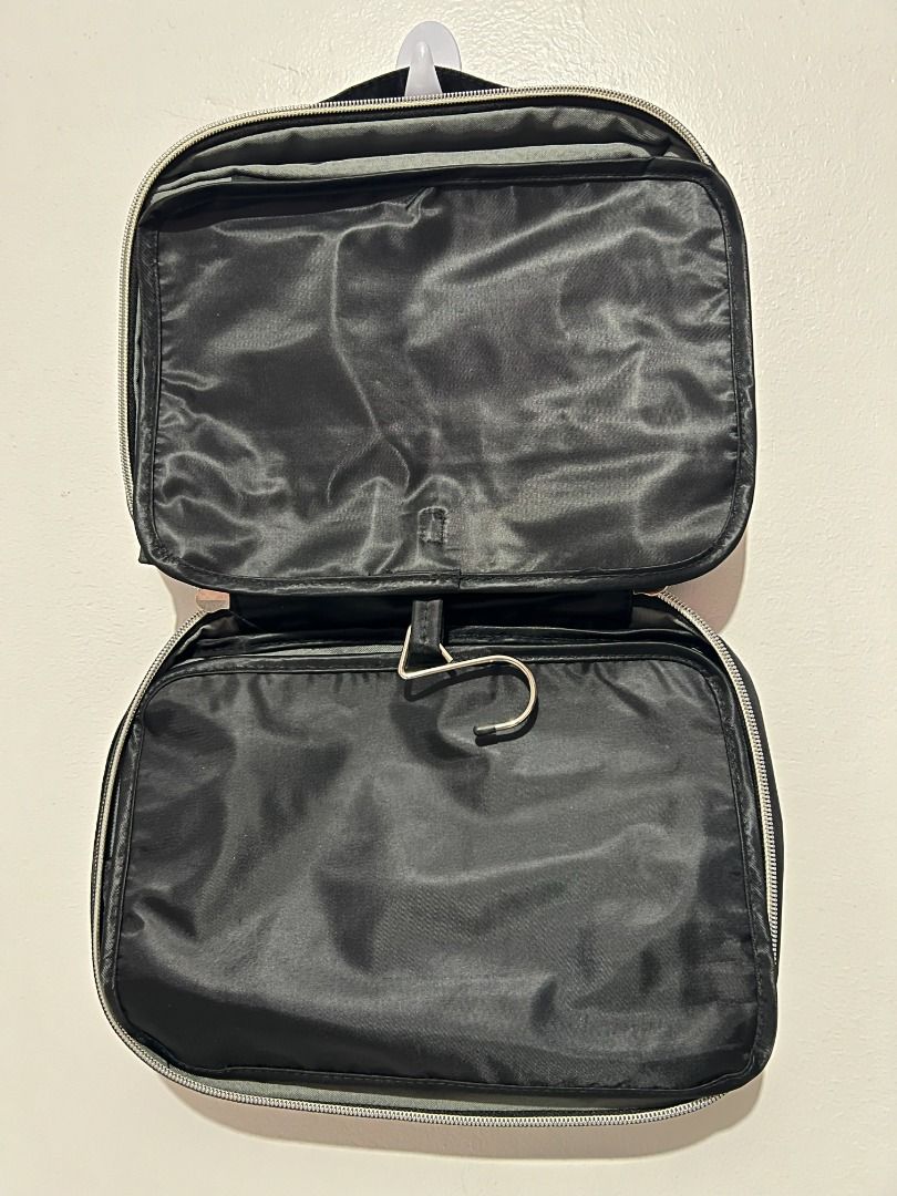 Jagurds Hanging Travel Bag (Category: Sling Bags) located in Davao. Submitted by jpnusapasabuyfindsdvo (Listing ID 1464698693, Image 3). Description: - Brand: Jagurds - Color: Classic Black - Multiple zippered compartments with clear plastic windows for easy visibility - Built-in sturdy hook for convenient hanging on doors or bathroom fixtures - Compact foldable design transforms into a neat rectangular pouch - Stylish silver logo plate detail on